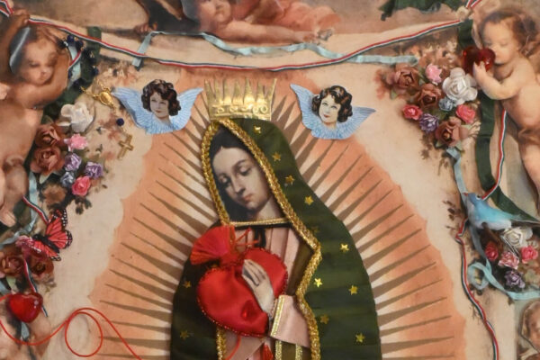 Obra religiosa de la Virgen de Guadalupe con manto verde, aureola radiante y decoraciones aplicadas de flores y corazón.